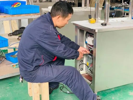 Technician installing wiring inside a pharmaceutical machine electrical cabinet